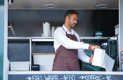 Waiter standing at food truck counter with paper towel